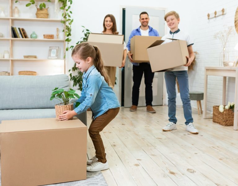 Family With Kids Moving House Unpacking Boxes In New Flat